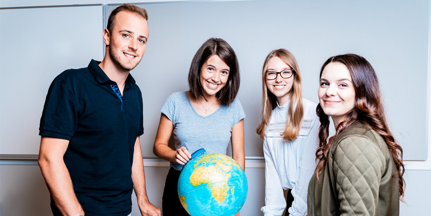 Studierende mit Globus