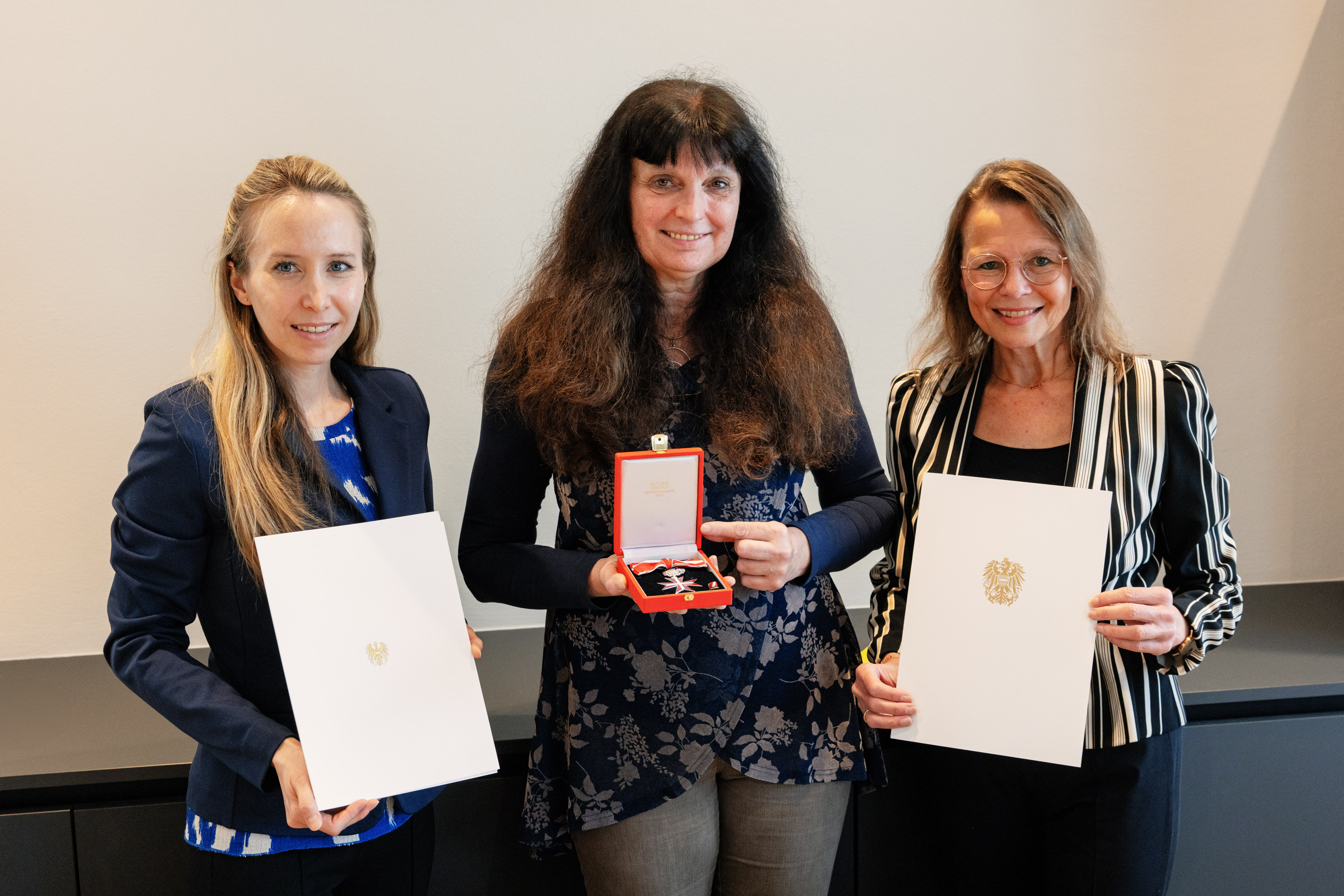 v.l.n.r.: Rektoratsdirektorin Tanja Thammerl mit Urkunde, Gabriele Hieß-Bergmann mit Ehrenzeichen, Rektorin Beatrix Karl mit Urkunde