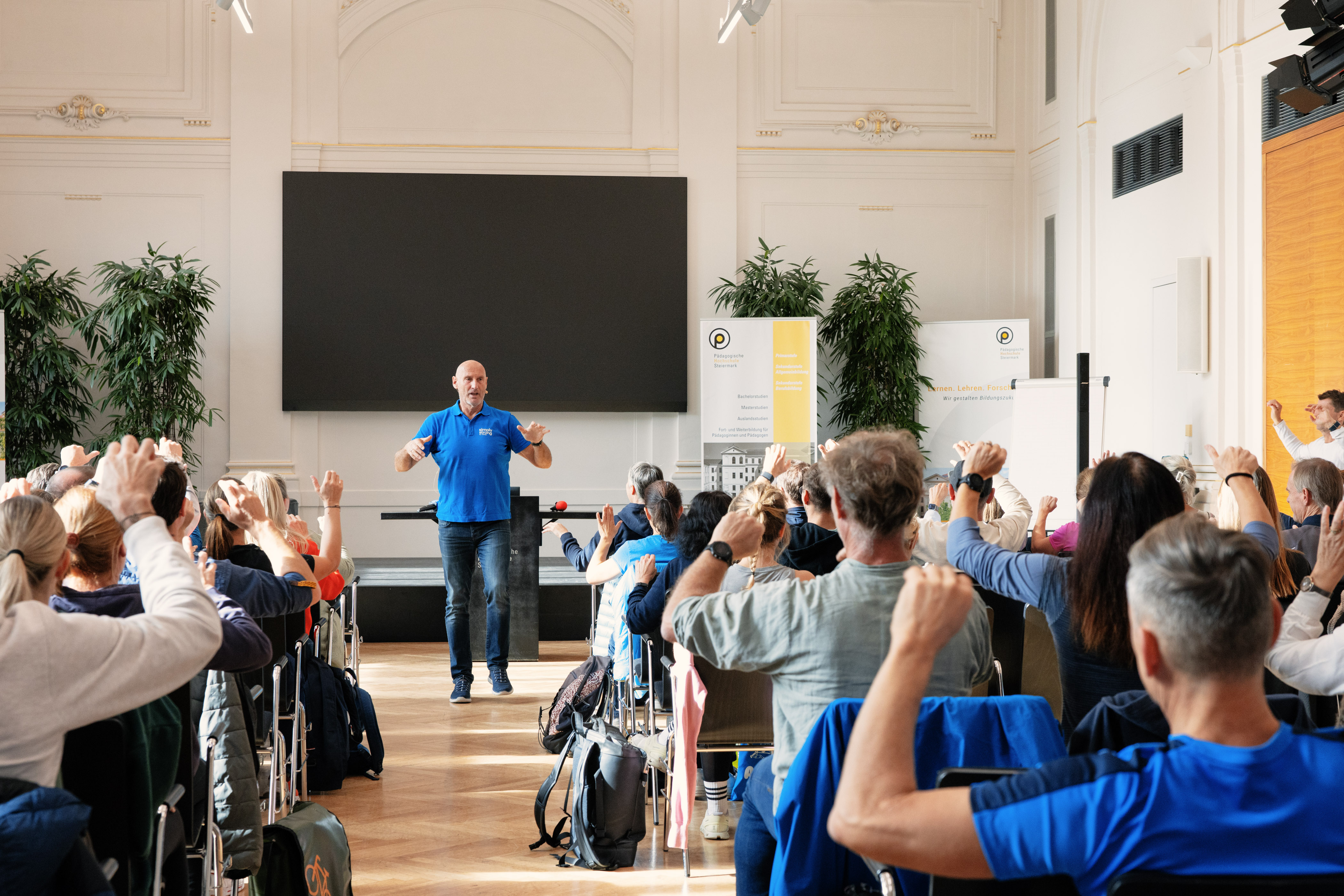 Personen hören Vortrag in der Aula