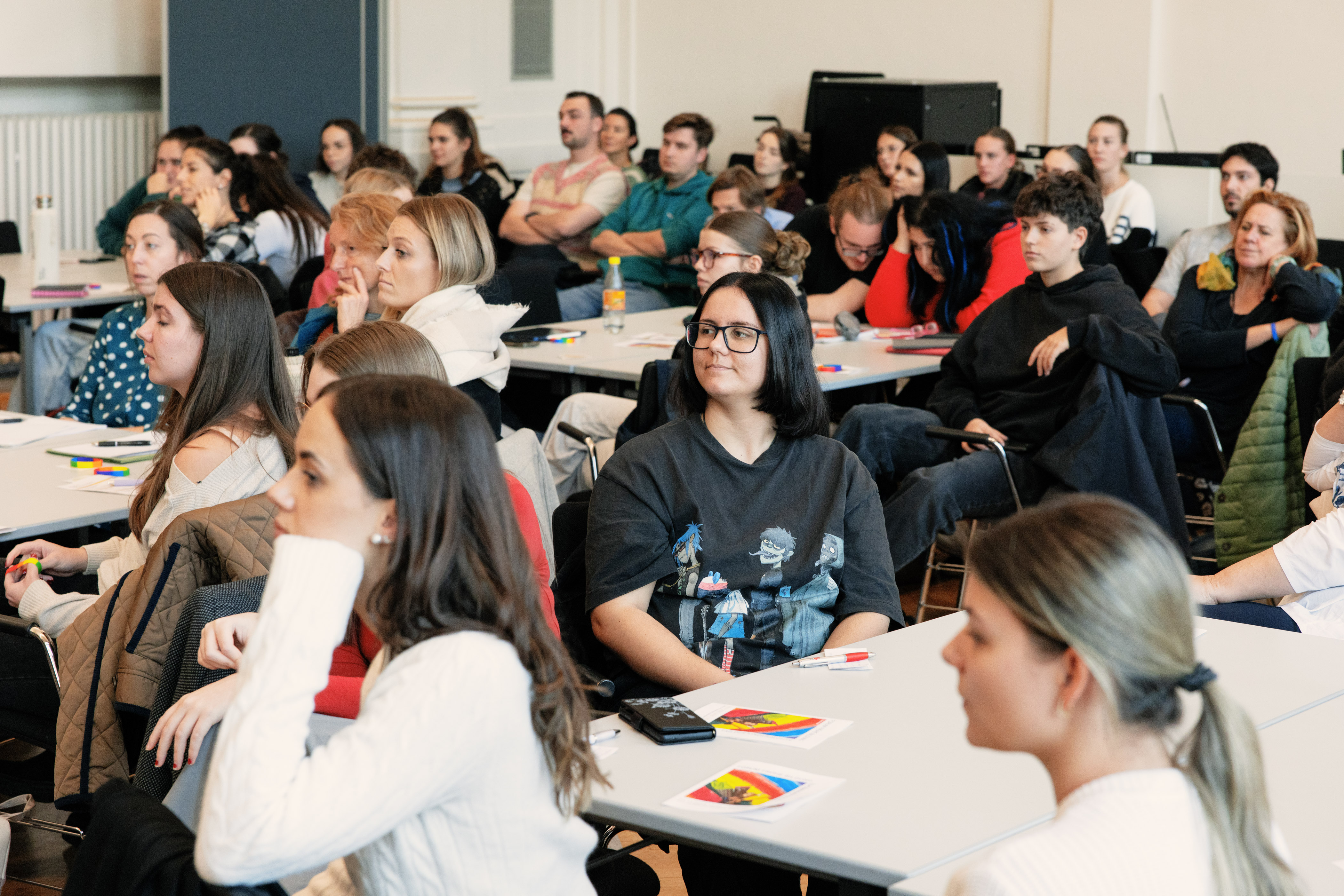 viele Personen sitzen im Publikum und hören aufmerksam zu