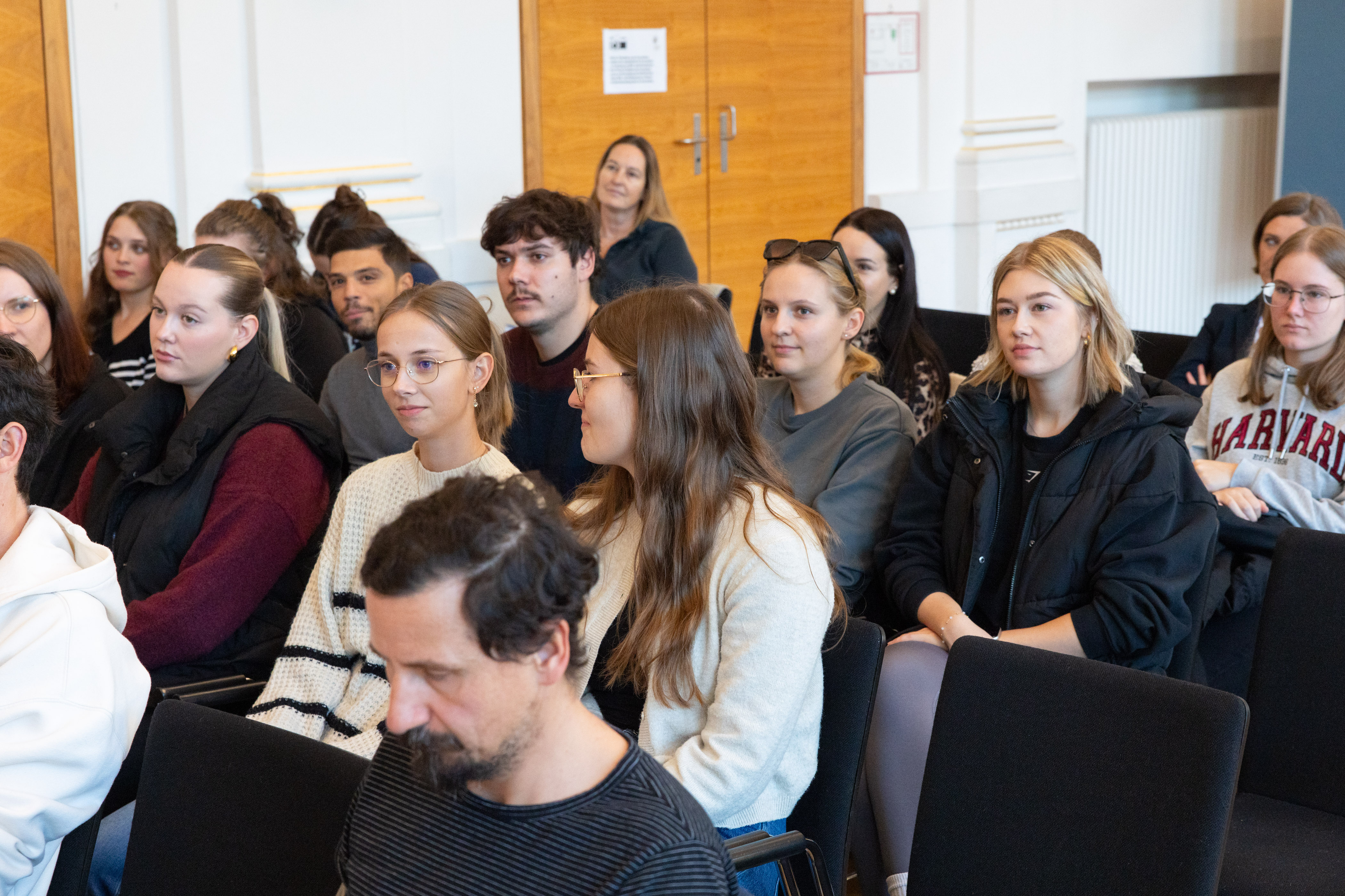 Frauen und Männer sitzen im Publikum 