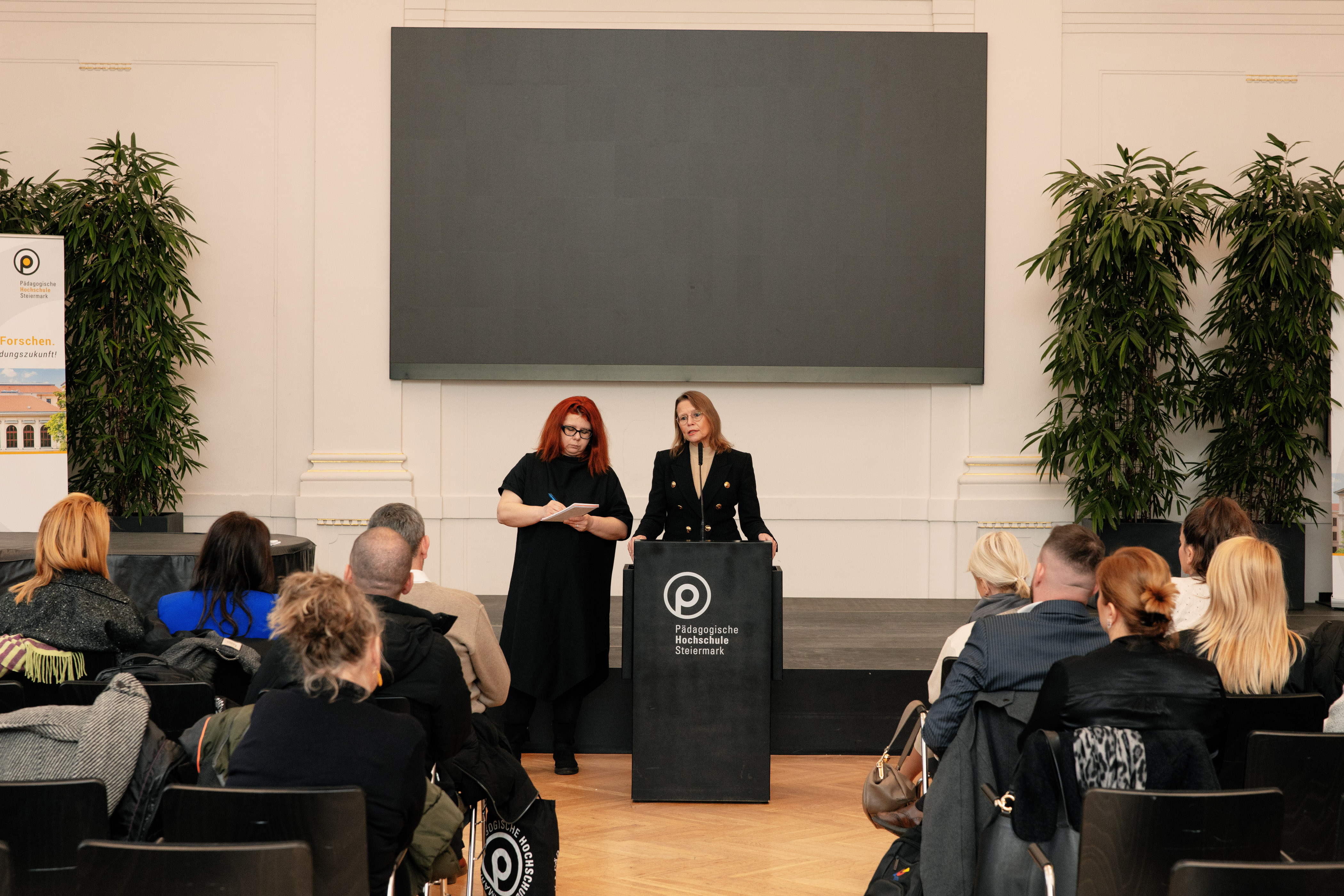Mneschen sitzen in der Aula