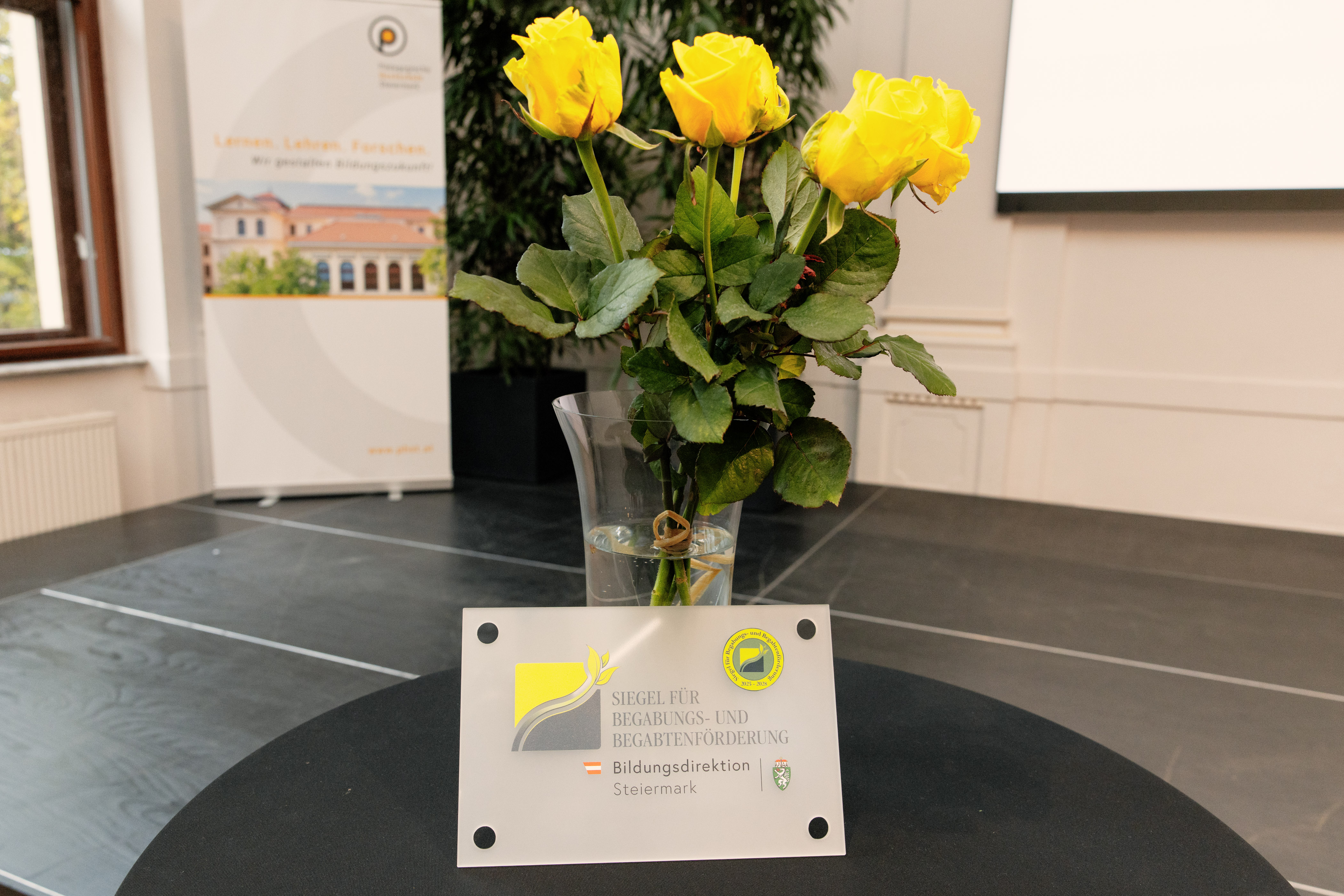 Siegel steht vor gelben Rosen