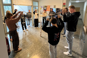 Personen machen eine Aktivität wo alle Fäden in den Händen halten