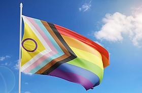 Wehende Prideflag vor blauem Himmel