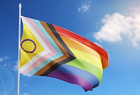 Wehende Prideflag vor blauem Himmel