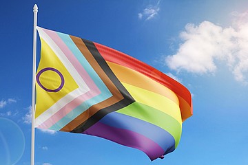Wehende Prideflag vor blauem Himmel