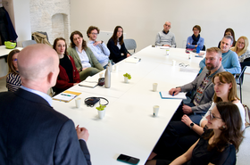 Personen sitzen um einen Tisch herum 