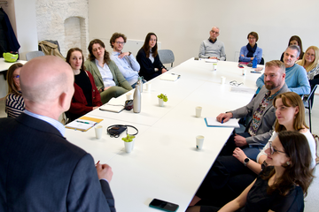 Personen sitzen um einen Tisch herum 