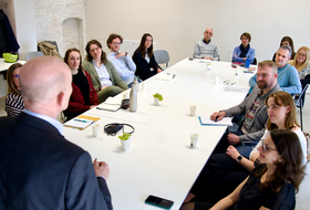 Personen sitzen um einen Tisch herum 