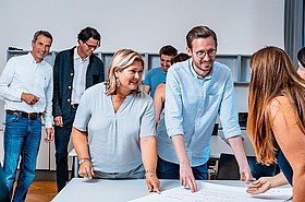Mehrere Personen sitzen an Tisch