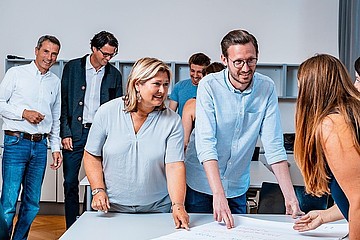 Mehrere Personen sitzen an Tisch