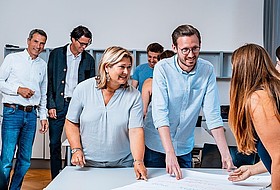 Mehrere Personen sitzen an Tisch