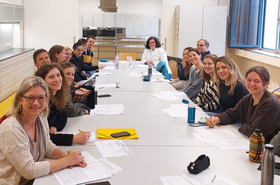 Viele Personen sitzen an einem Tisch