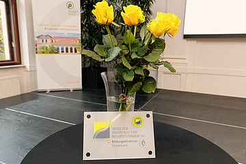 Siegel steht vor gelben Rosen