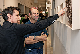 Zwei Männer betrachten eine Arbeit