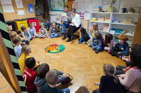 Zwei Studierende lesen Kindern Bücher vor 