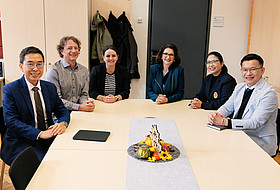 Personen sitzen an Tisch 