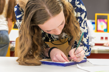 Eine Frau schreibt auf einem Zettel 