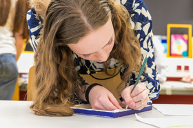 Eine Frau schreibt auf einem Zettel 