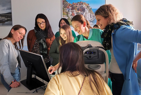 Personen stehen um Computer herum