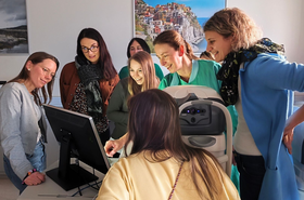 Personen stehen um Computer herum