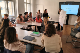 Studierende sitzen an Tischen