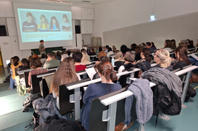 Personen sitzen und hören Vortrag zu 