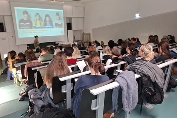 Personen sitzen und hören Vortrag zu 