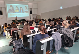 Personen sitzen und hören Vortrag zu 