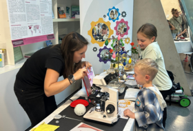 Frau beim Experimentieren vor Kindern