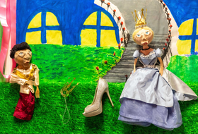 Zwei Puppen liegen auf gemaltem Untergrund