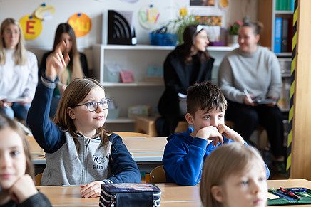 Schulkinder in Klasse, Mädchen zeigt auf