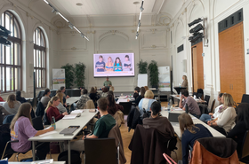Personen sitzen in der Aula während Vortrag