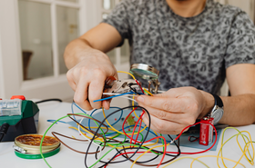 Mann arbeitet mit Stromkabeln 