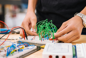 Person bastelt an einem Stromkreis