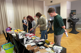 Personen stehen vor Tisch