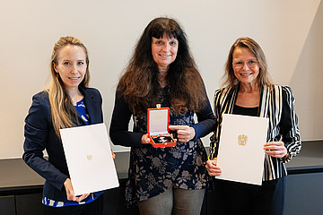 v.l.n.r.: Rektoratsdirektorin Tanja Thammerl mit Urkunde, Gabriele Hieß-Bergmann mit Ehrenzeichen, Rektorin Beatrix Karl mit Urkunde