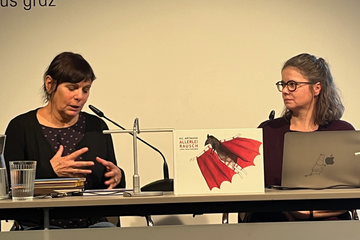 Zwei Frauen sitzen nebeneinander 