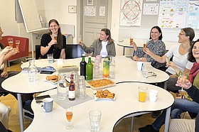 Personen von iPrimar an einem Tisch, halten Sektgläser hoch