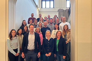 Menschen stehen in Treppenhaus